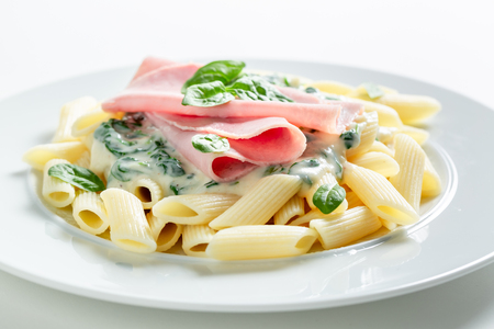 Hot pasta with bechamel sauce, ham and spinachの写真素材