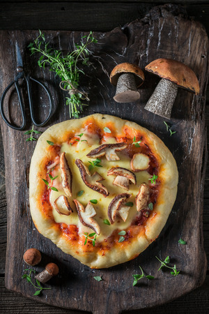 Tasty and homemade rustic pizza with mushroomsの写真素材