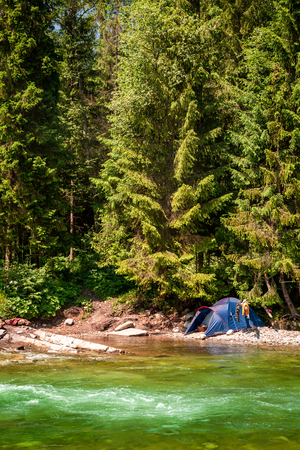 Breathtaking wild river and tent in Tatras mountainsの写真素材