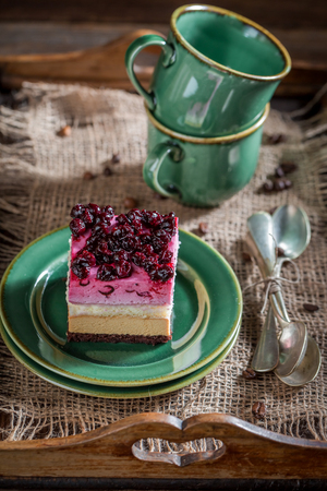Closeup of sweet cake with black currant on wooden trayの写真素材