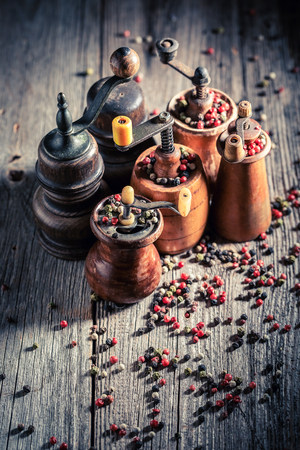 Rustic pepper mills with different types of pepperの写真素材