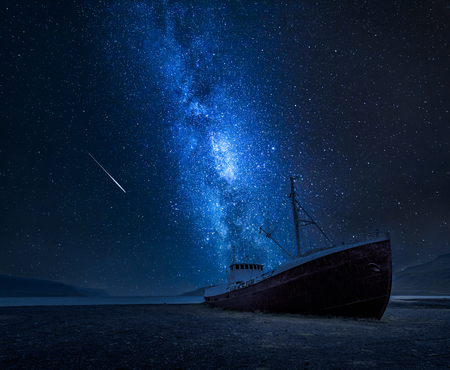 Milky way over a shipwreck on the shore in Icelandの写真素材