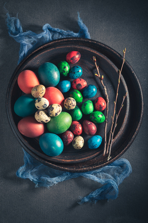 Quail and hen eggs for Easter in old clay plateの写真素材