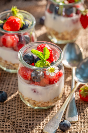 Homemade oat flakes in jar with yoghurt and berriesの写真素材