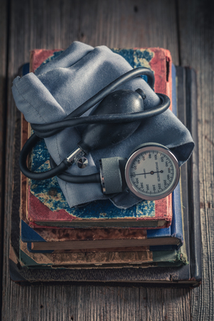 Classic blood pressure monitor on the pile of old booksの写真素材