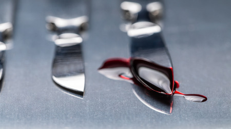 Stainless steel scalpels on stainless steel table with bloodの写真素材
