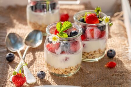 Closeup of oat flakes in jar with yoghurt and berriesの写真素材