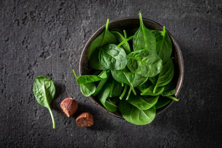 Raw green spinach on gray stone tableの写真素材