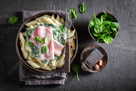 Delicious penne with ham, spinach and bechamel sauceの写真素材