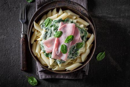 Delicious pasta with spinach, bechamel sauce and hamの写真素材