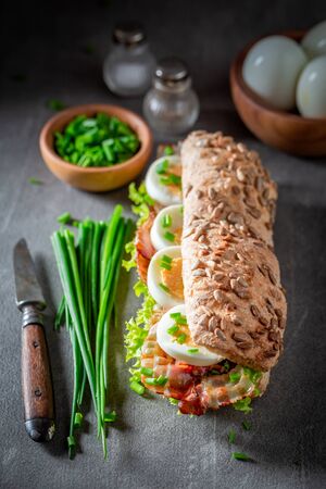 Delicious sandwich with bacon, chive and eggsの写真素材