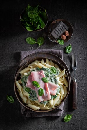 Tasty penne with ham, spinach and bechamel sauceの写真素材
