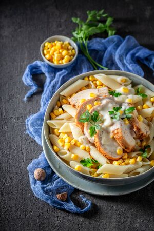 Tasty penne with bechamel sauce, corn and chickenの写真素材