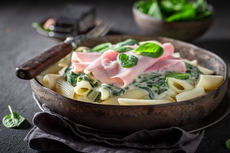 Delicious penne with spinach, bechamel sauce and hamの写真素材