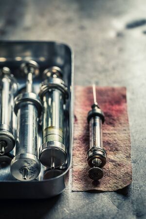 Classic syringes with a needle prepared on red bandageの写真素材