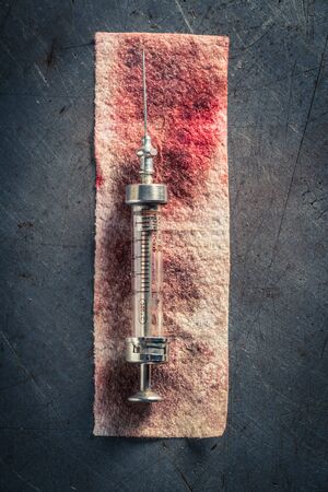 Top view of syringes with a needle on red bandageの写真素材