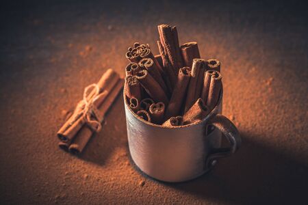 Top view of cinnamon bark and powder in metal mugの写真素材