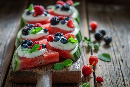 Watermelon pizza with fresh berry fruits and whipped creamの写真素材
