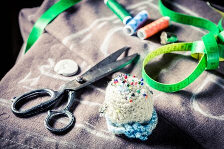 Closeup of sewing threads, scissors, cloth and tape measure