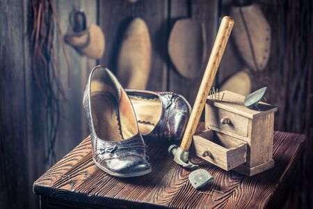 Shoemaker workplace with shoes, laces on wooden chairの写真素材