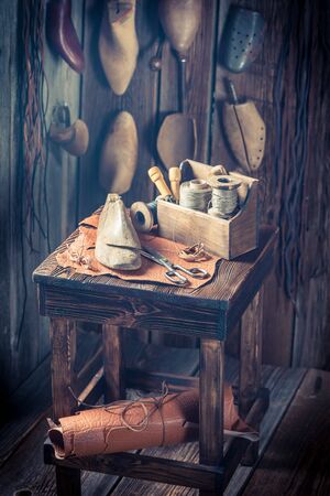 Rustic shoemaker workplace with shoes, laces and toolsの写真素材