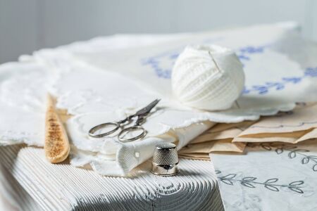 Thread, scissors and homemade white embroidered napkinsの写真素材