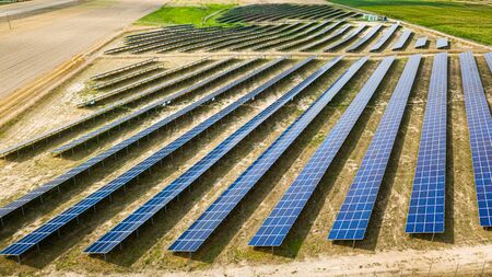 Flying above amazing view of solar panels on dry field