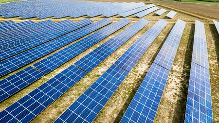 Flying above stunning view of solar panels on dry field