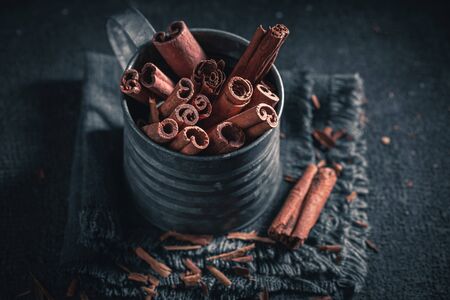 Heap of cinnamon sticks in old metal mugの写真素材