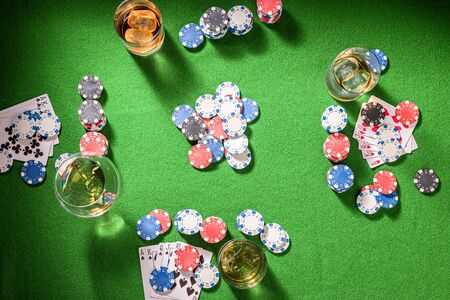 Green table for poker with whisky and cards