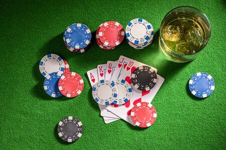 Four-person gambling table with whisky and cardsの写真素材