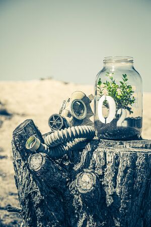 Strange jar with plant and mask as air pollution symbolの写真素材