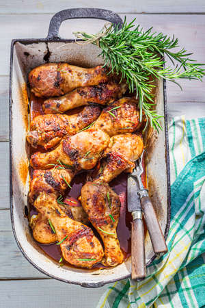 Roasted chicken legs with rosemary on old white tableの写真素材