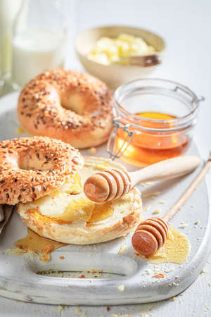 Sweet bagel with honey and butter in the morningの写真素材