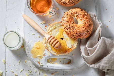 Golden bagel with honey and butter for breakfastの写真素材