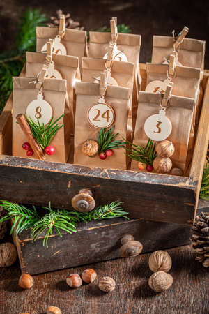 Handmade Christmas Advent Calendar stacked in a wooden drawer on wooden tableの写真素材
