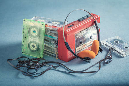 Antique cassette tape with headphones and player on blue sofaの写真素材