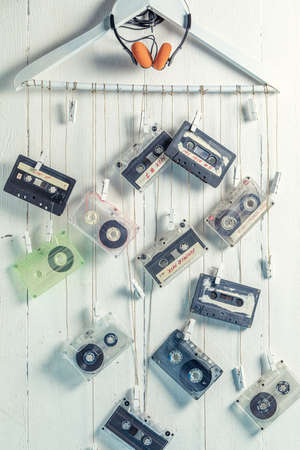 Several cassette tapes hanging on a clothes hanger on white backgroundの写真素材