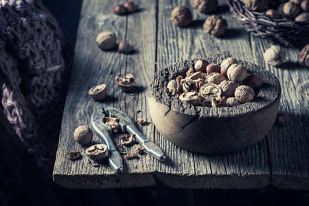 Closeup of various nuts and nutcracker on rustic wooden tableの写真素材