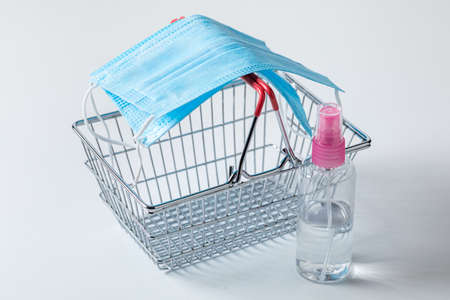 Shopping basket with mask as protection when shopping on white background