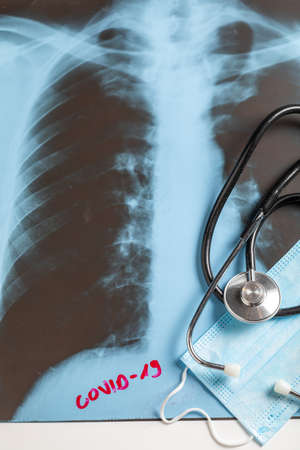 Sick lungs x-ray, protective mask and stethoscope on white background