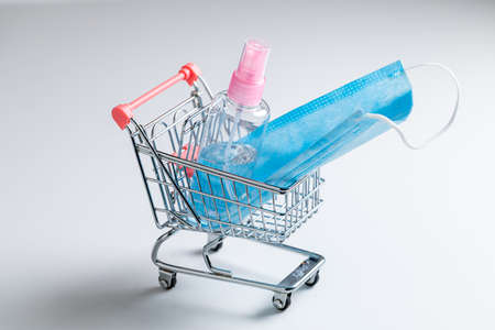 Medical mask and shopping cart during Coronavirus COVID-19 pandemic on white backgroundの写真素材