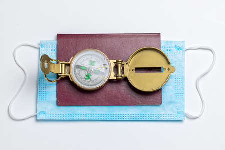 Mask, compass and passport as travel restrictions. Covid-19 restriction.