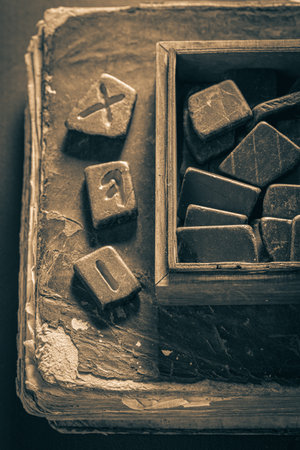 Closeup of antique rune stones with futhark alphabet and old bookの写真素材