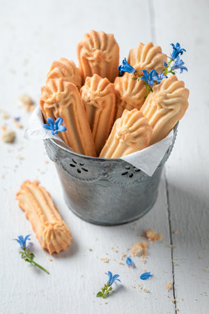 Delicious shortbread cookies served with milk and straw on white table