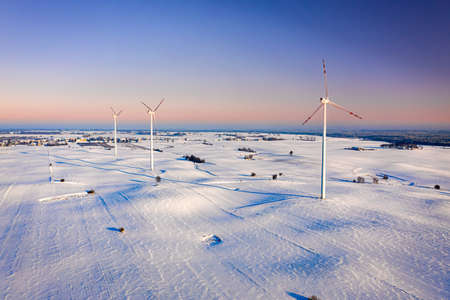 Wind turbine on snowy field in winter. Alternative energy in Poland. Aerial view of nature in Polandの写真素材