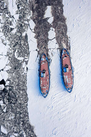 Two icebreakers on Vistula river crush the ice in winter, Poland