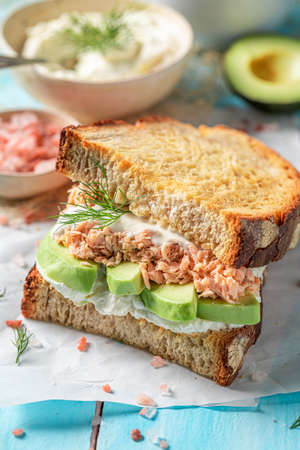 Homemade sandwich with salmon and avocado for healthy breakfast. Toast with salmon and avocado.の写真素材