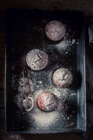 Sweet chocolate muffin with caster sugar. Chocolate cupcake with nuts.の写真素材