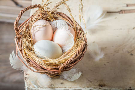 Closeup of ecological eggs in old wicker basket. Eggs from a free-range farm.の写真素材